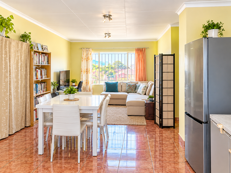 Open-plan living and dining area featuring ceramic tiled flooring, security bars on windows, and neutral wall finishes, creating a functional and connected living space.