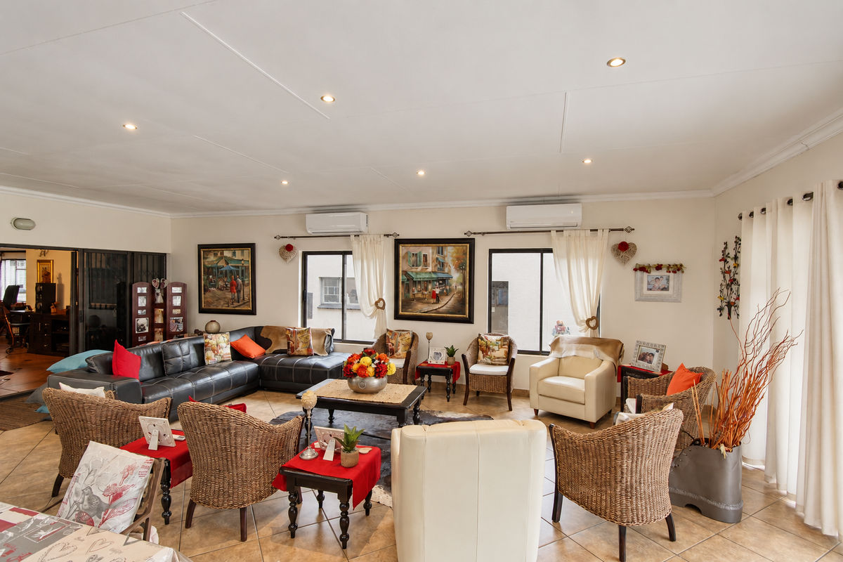 Spacious living room featuring tiled flooring, recessed lighting, and dual split-system air conditioning units, offering a comfortable and well-maintained living space.