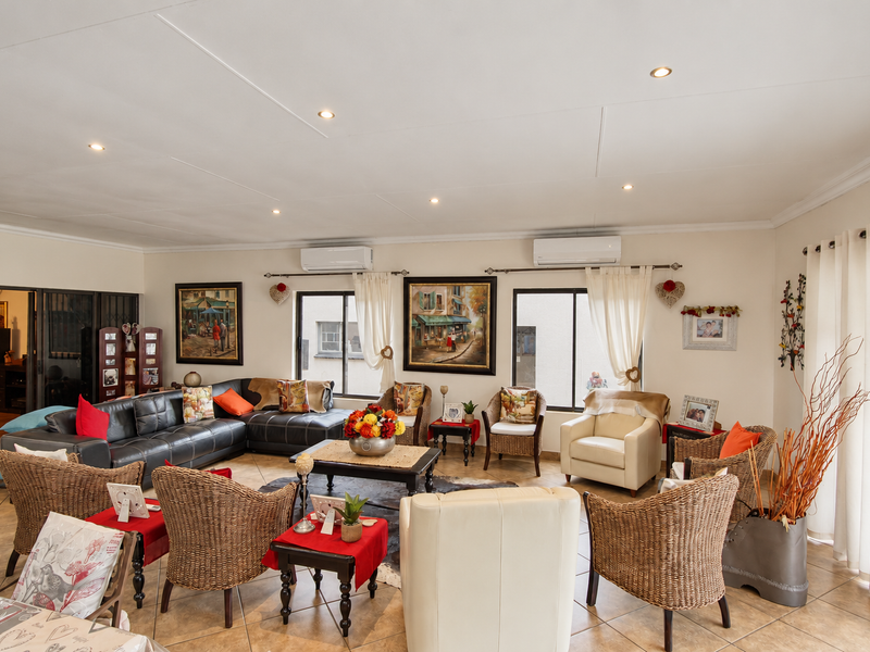Spacious living room featuring tiled flooring, recessed lighting, and dual split-system air conditioning units, offering a comfortable and well-maintained living space.