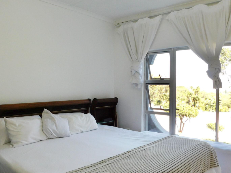 A bright bedroom featuring a sliding glass door that provides natural light and access to the outdoor area.