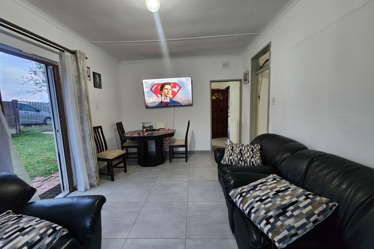 A living room featuring tiled flooring, a sliding glass door providing outdoor access, and neutral wall finishes.
