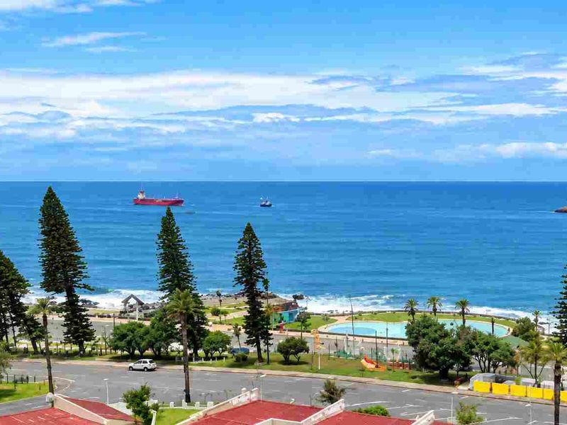 A panoramic elevated view overlooking the coastline, ocean, and public park area.