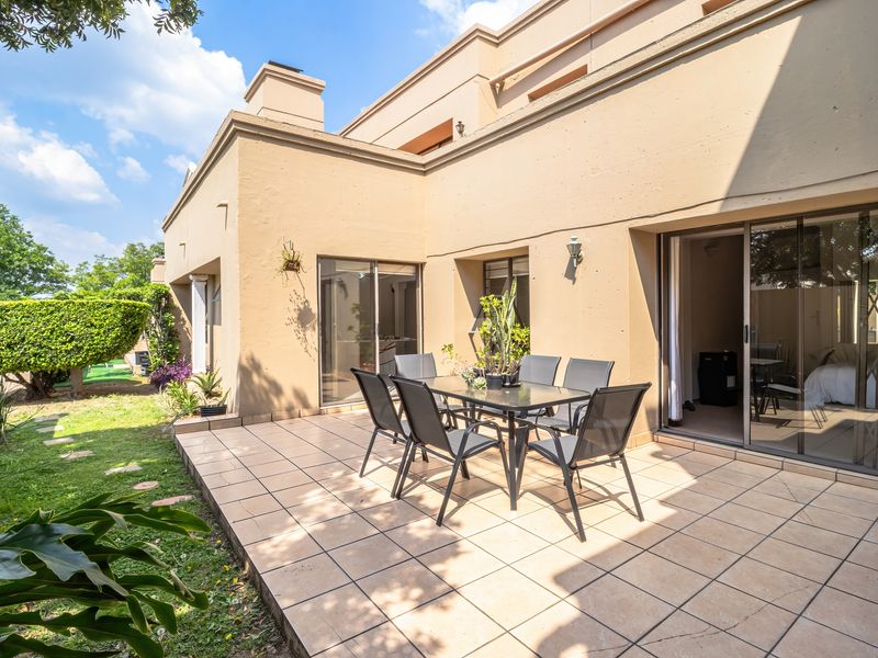 A spacious tiled patio area featuring sliding glass door access to the interior, perfect for outdoor dining and entertaining.