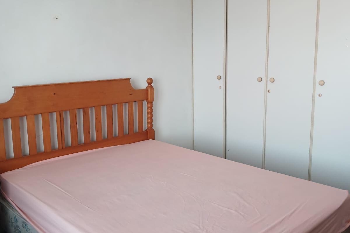 A bedroom featuring built-in white cupboards providing ample storage space.