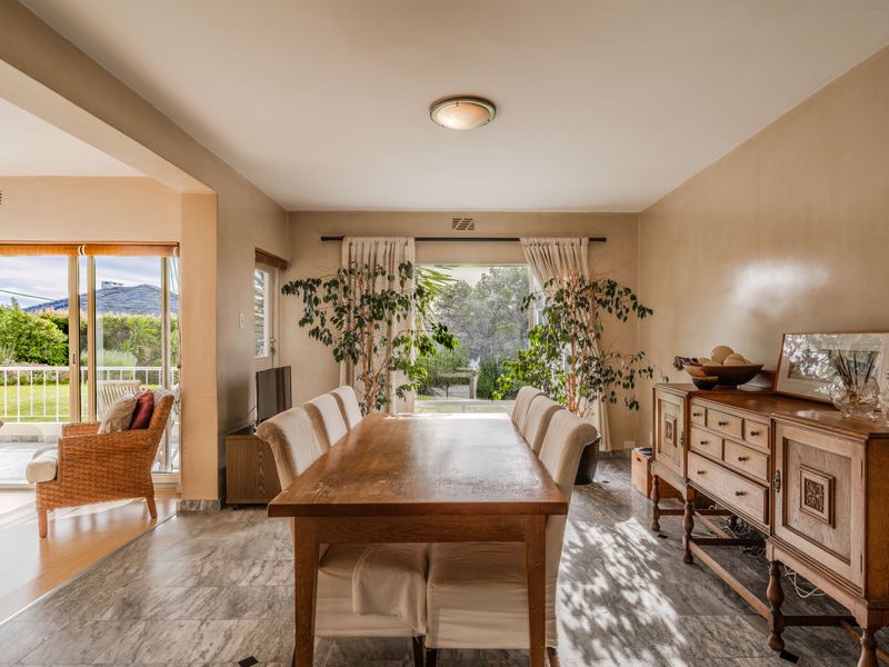 A bright dining room featuring tiled flooring and large sliding glass doors that provide direct access to an outdoor patio area.