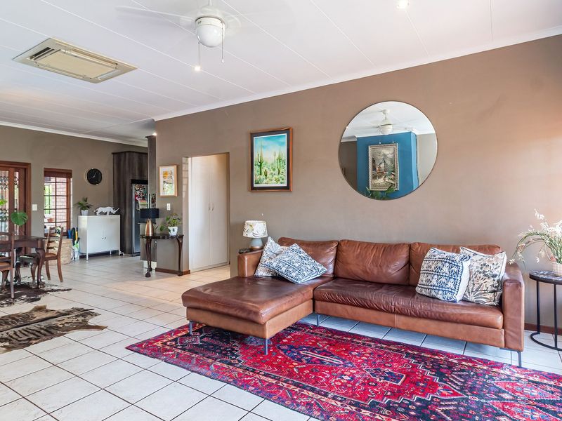 Spacious open-plan living and dining area featuring neutral wall tones, tiled flooring, and large sliding doors providing access to the outdoor space.