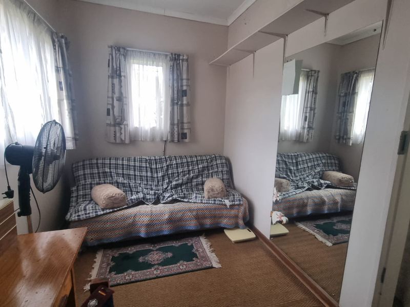 A bedroom featuring built-in mirrored wardrobes and carpet flooring, offering a functional space with potential for modernization.