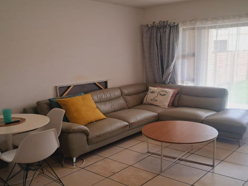 A living room area featuring tiled flooring and a sliding glass door providing access to the exterior.