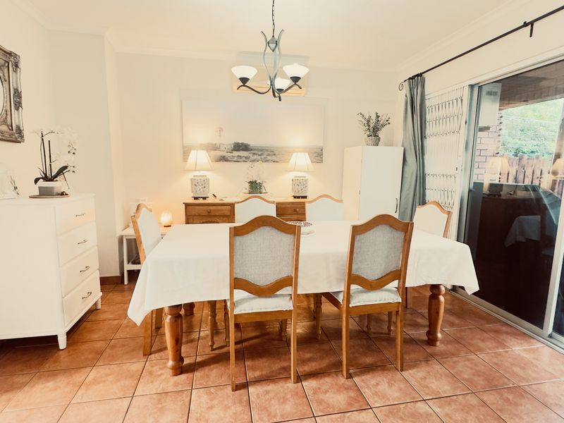 A dining room featuring terracotta floor tiles and a large sliding glass door providing access to the patio area.