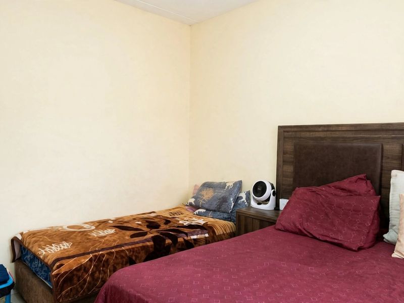 A standard bedroom featuring neutral wall finishes and space for multiple beds.