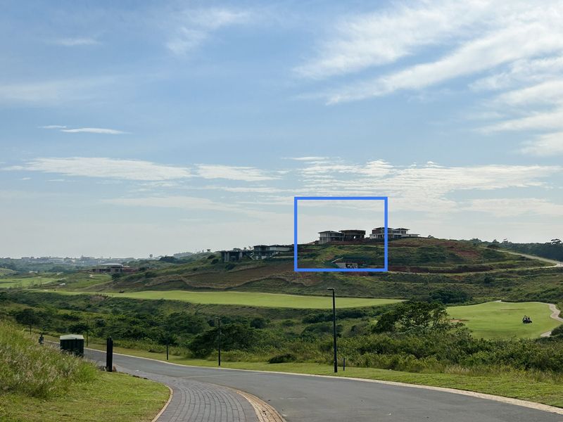 A scenic elevated view overlooking a golf course and surrounding estate landscape with residential properties visible in the distance.