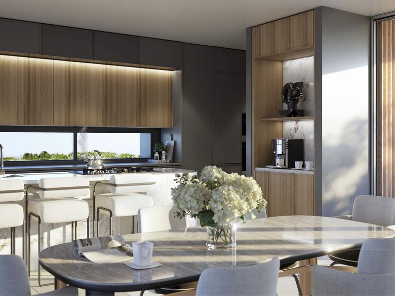 Modern open-plan kitchen and dining area featuring high-end marble finishes, sleek integrated cabinetry, and seamless indoor-outdoor flow through large sliding glass doors.