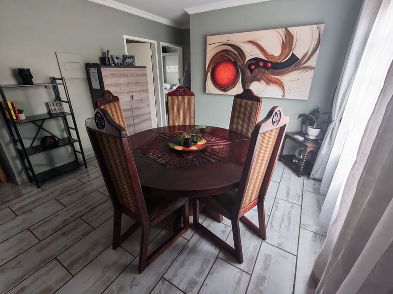 A dining room featuring tiled flooring and crown molding, providing a functional space for meals.