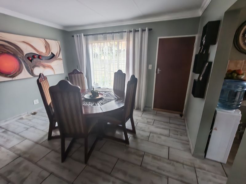 A dining room featuring tiled flooring, coved ceilings, and a sliding glass door providing natural light and access to the exterior.