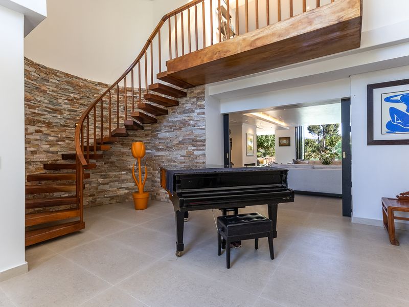 Spacious living area featuring a striking wooden spiral staircase, stone feature wall, and large sliding doors leading to an adjacent room.