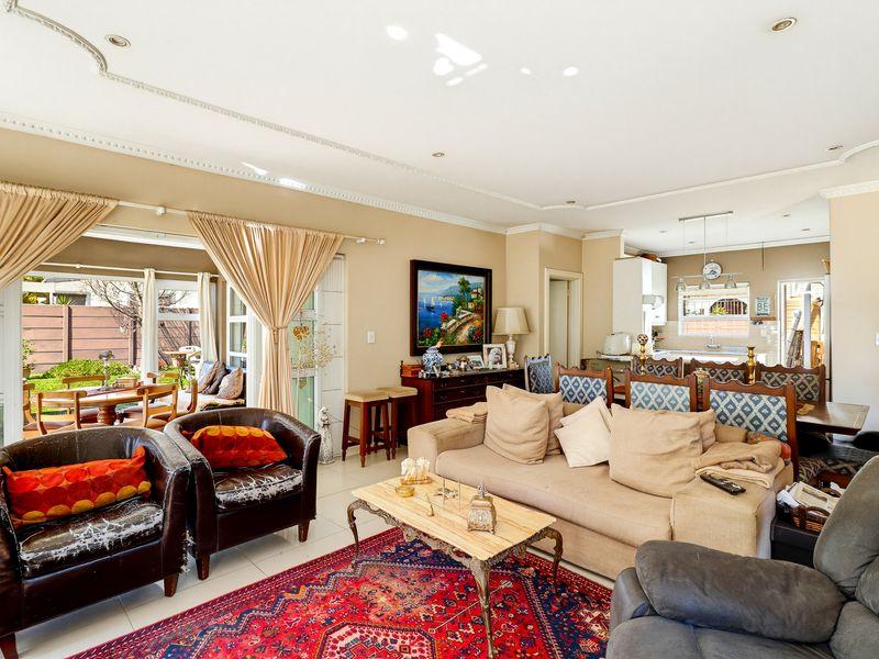Spacious open-plan living and dining area featuring tiled floors, recessed lighting, and direct access to an outdoor patio through sliding glass doors.