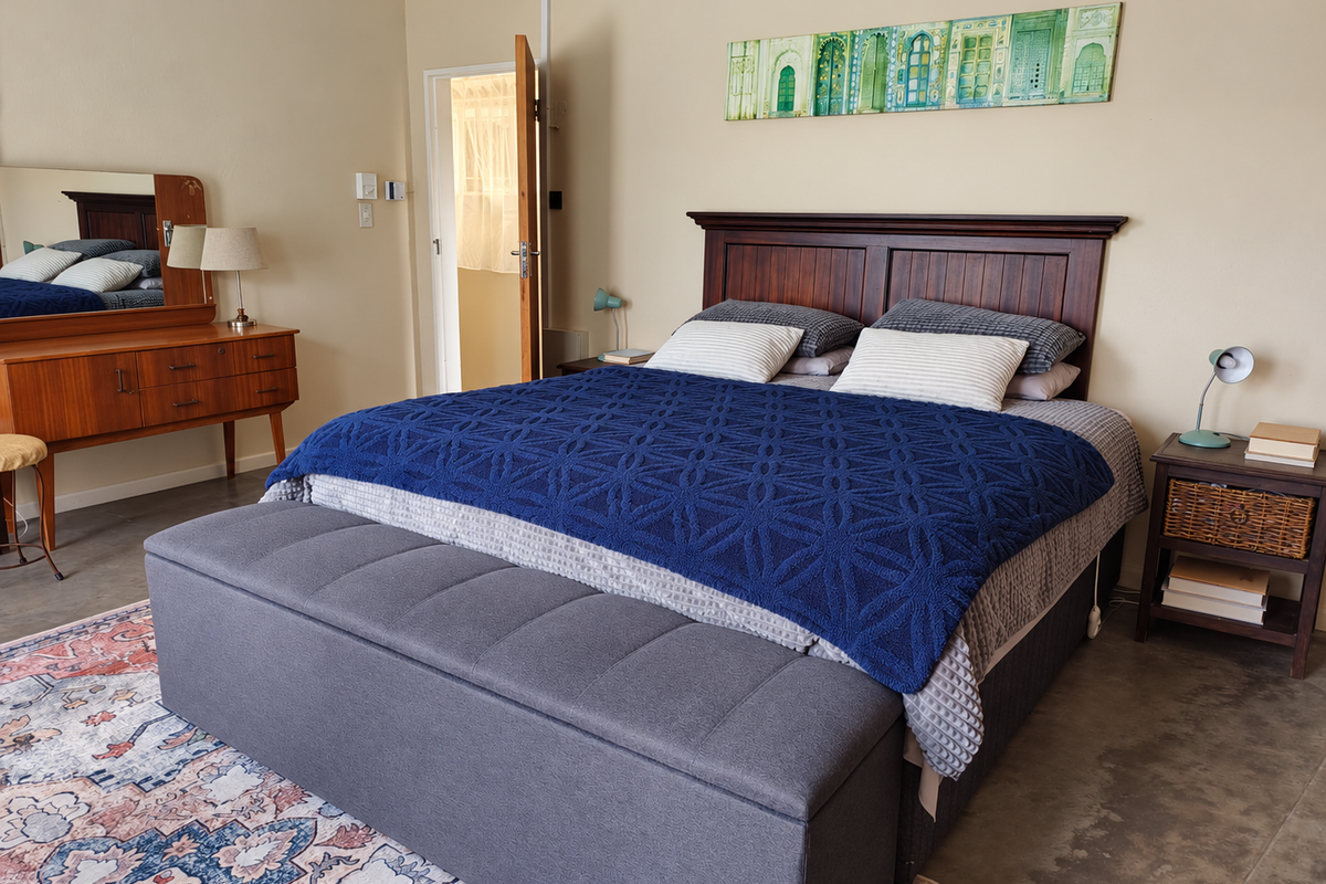 A well-maintained bedroom featuring polished concrete floors and neutral wall tones, providing a clean and functional living space.