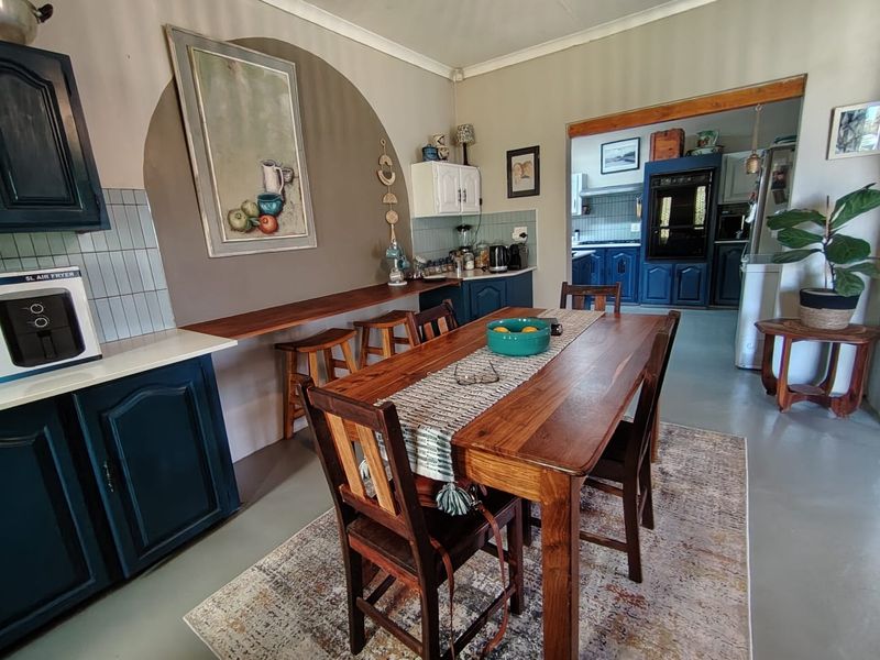 Open plan dining area featuring a breakfast bar, built-in cabinetry, and a seamless transition into the adjacent kitchen space.