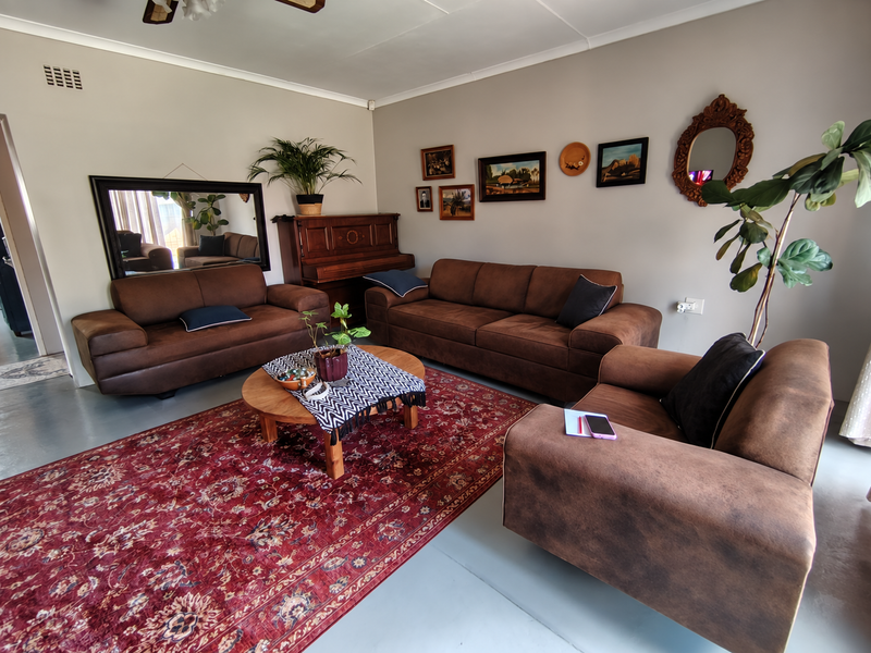 A comfortable living room featuring neutral walls, a ceiling fan, and smooth flooring, providing a versatile space for relaxation and family gatherings.