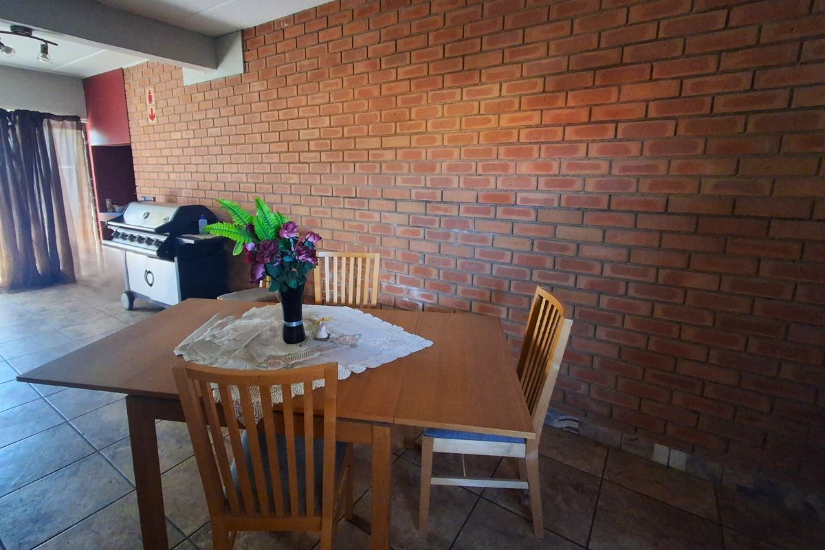 Dining area featuring a prominent exposed brick feature wall and durable tiled flooring, creating a rustic and functional space.