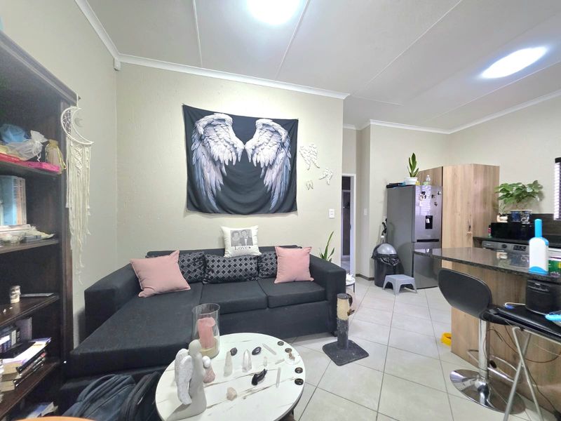 Open plan living area featuring tiled flooring and a kitchen with granite countertops, providing a functional and connected space for daily living.