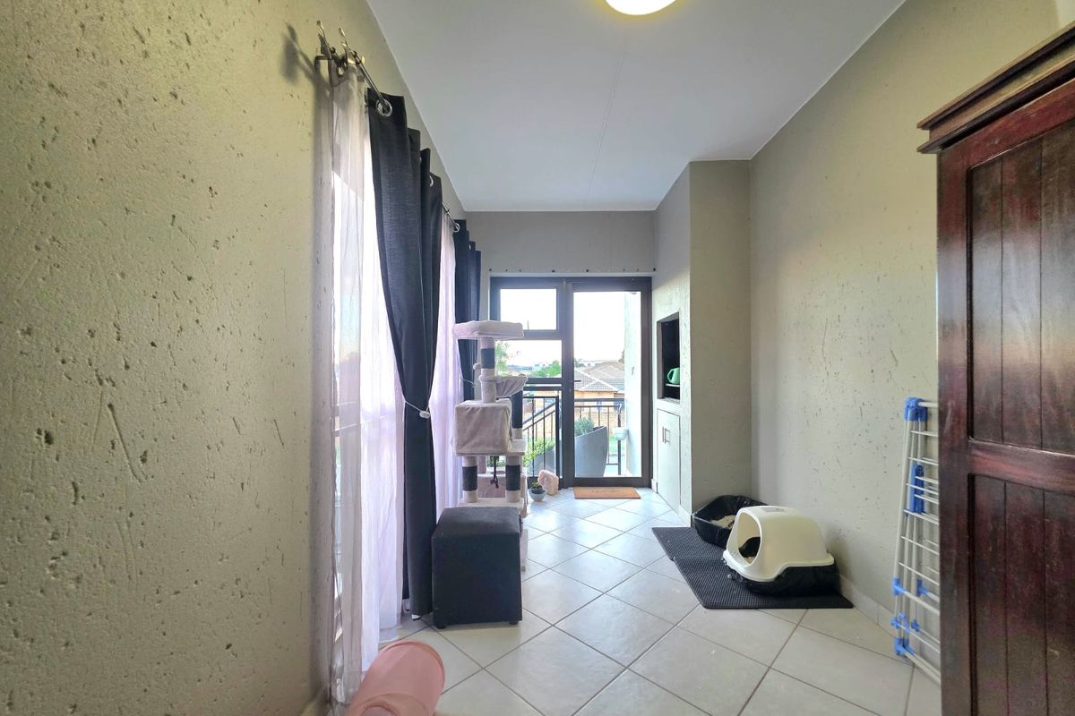 A functional living area featuring tiled flooring, built-in shelving, and a sliding glass door providing access to an outdoor space.