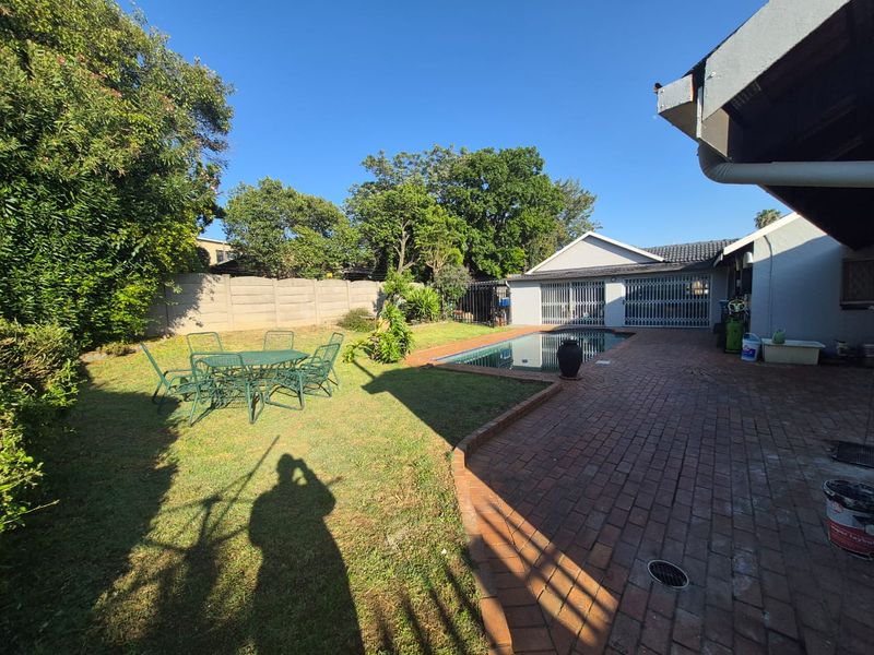 Outdoor pool area featuring a swimming pool, brick paved patio, and secure boundary walling, set within a private garden space.