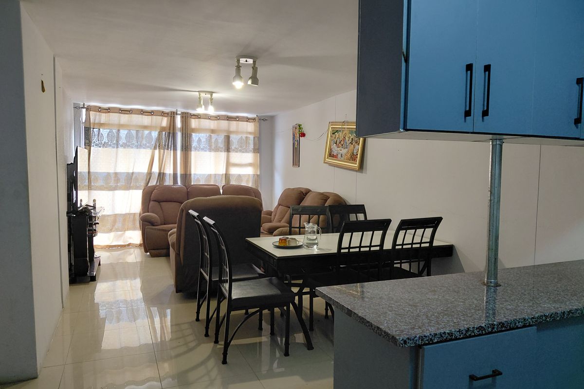 Open plan living and dining area featuring tiled flooring and a functional kitchen with granite countertops.