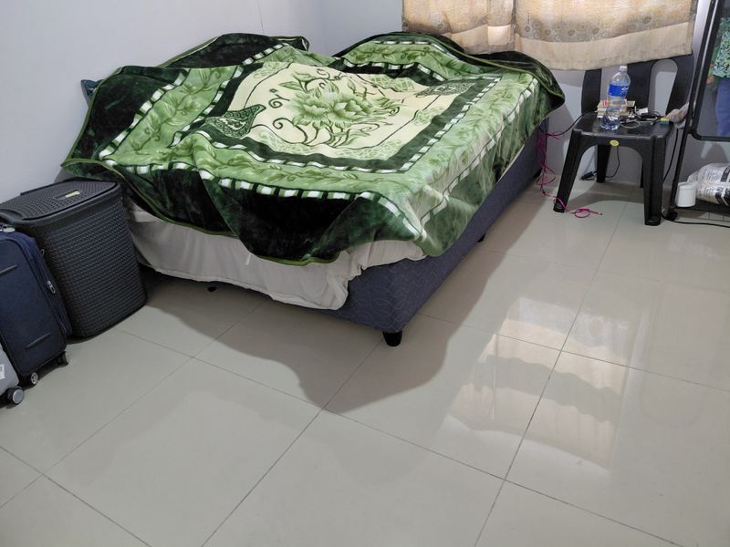 A bedroom featuring tiled flooring and a window with curtain rails.