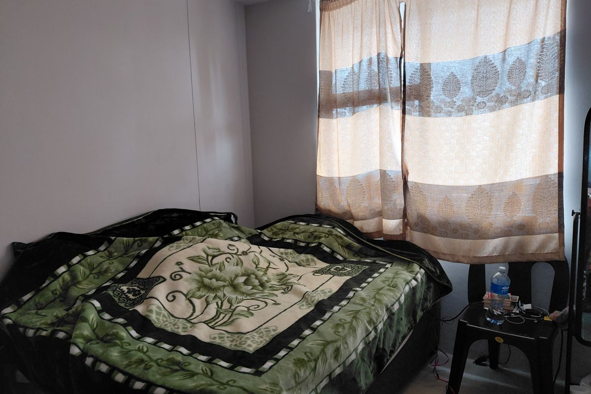 A standard bedroom featuring a window with installed curtain rails, providing natural light to the space.
