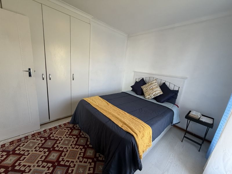 A bedroom featuring built-in wardrobes, laminate flooring, and coving, offering a neutral base for personalization.