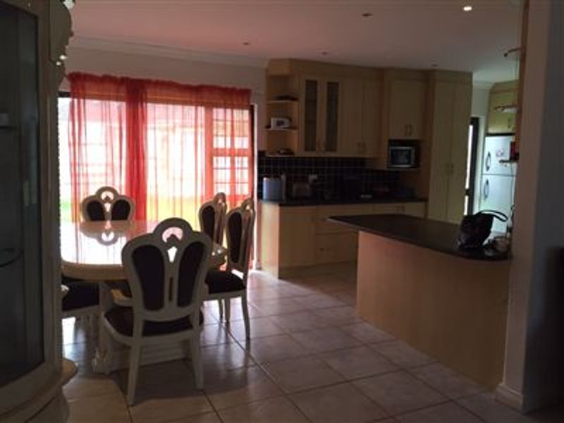 Open plan kitchen and dining area featuring tiled flooring, built-in cabinetry, and direct access to the outdoor area through sliding glass doors.