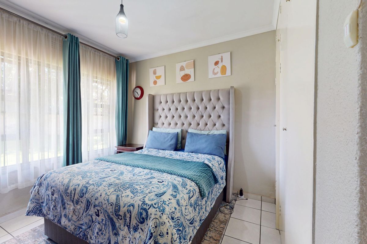 A well-lit bedroom featuring tiled flooring and built-in cupboards, offering a functional and comfortable living space.