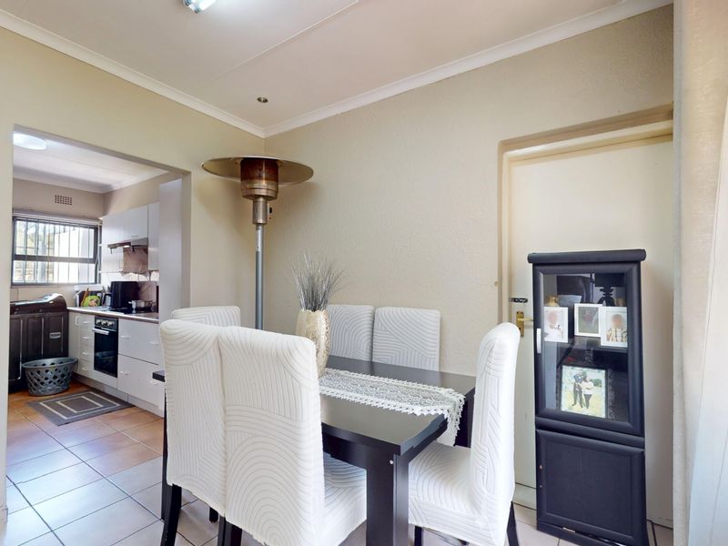 Open plan dining area with tiled flooring and coved ceilings, providing a seamless transition into the adjacent kitchen space.