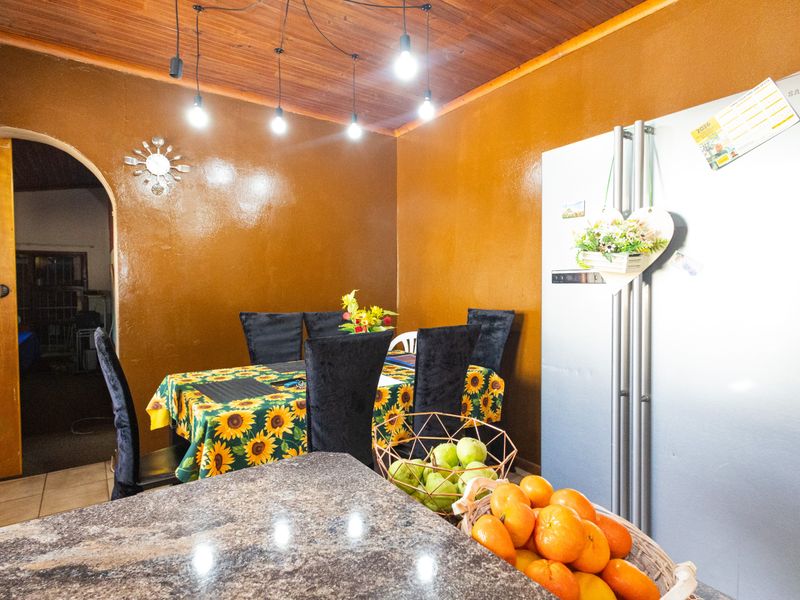 Kitchen area featuring a granite countertop, warm timber ceiling, and an arched doorway leading to adjacent living space.