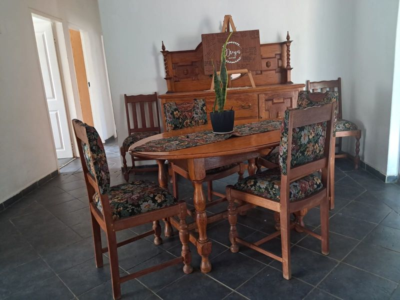 A dining room area featuring dark tiled flooring and neutral wall finishes.