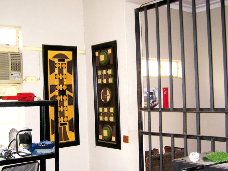An interior space featuring a wall-mounted air conditioning unit and a metal security gate, with decorative wall panels.