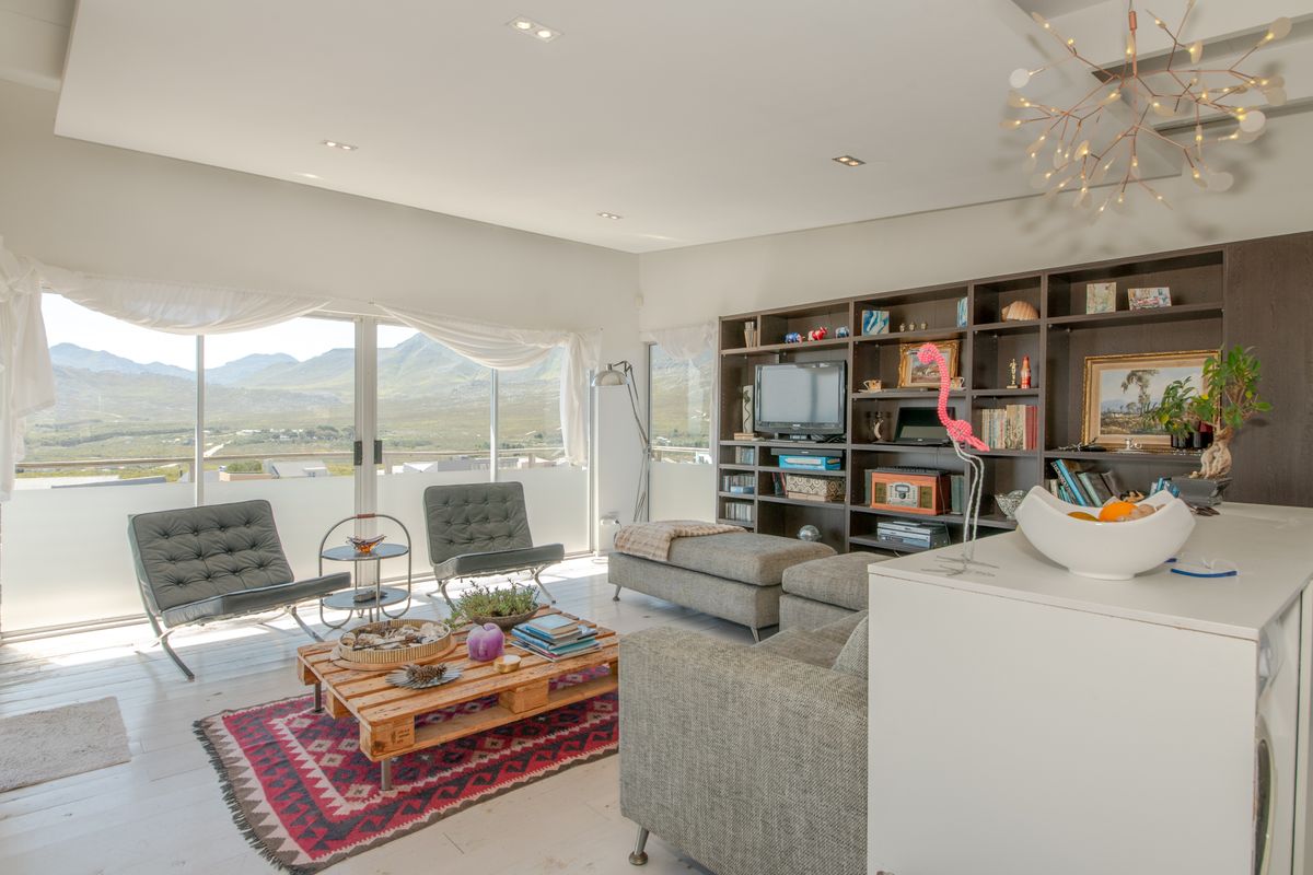 Spacious living room featuring built-in shelving, recessed lighting, and large sliding glass doors that offer expansive mountain views.