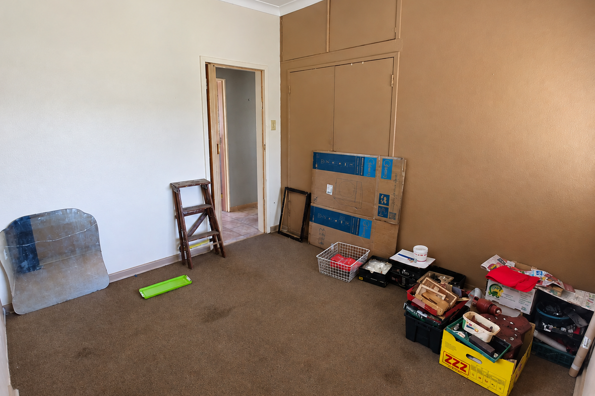 A bedroom featuring built-in cupboards and carpeted flooring, offering a blank canvas for renovation or restyling.