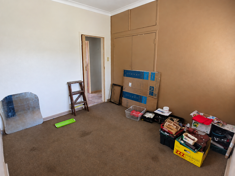 A bedroom featuring built-in cupboards and carpeted flooring, offering a blank canvas for renovation or restyling.