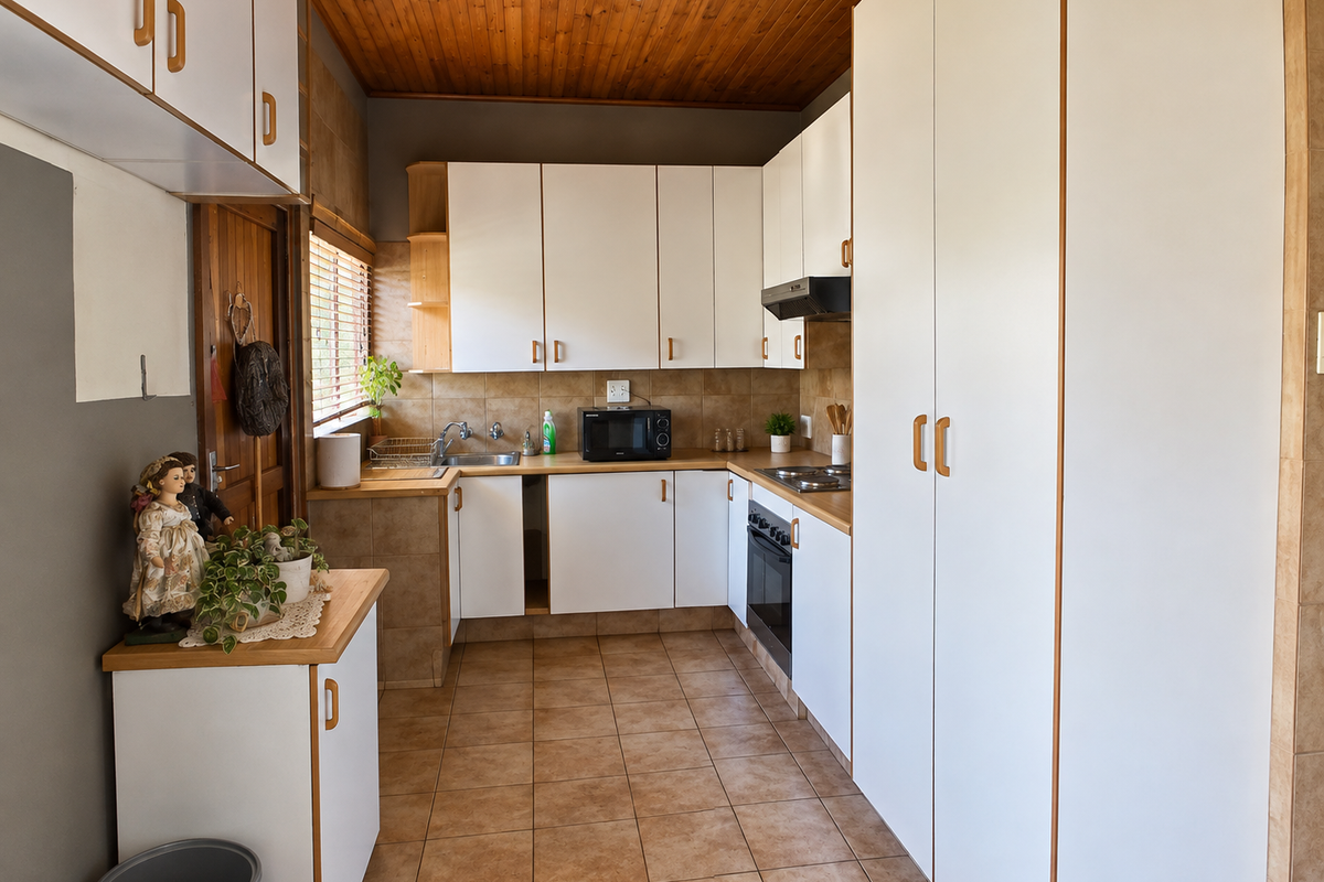 Functional kitchen featuring white cabinetry, laminate countertops, built-in oven and hob, tiled flooring, and a timber ceiling.