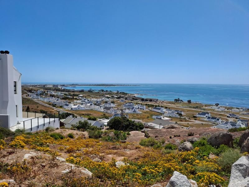 A scenic elevated view overlooking the coastal landscape, residential neighborhood, and the ocean.