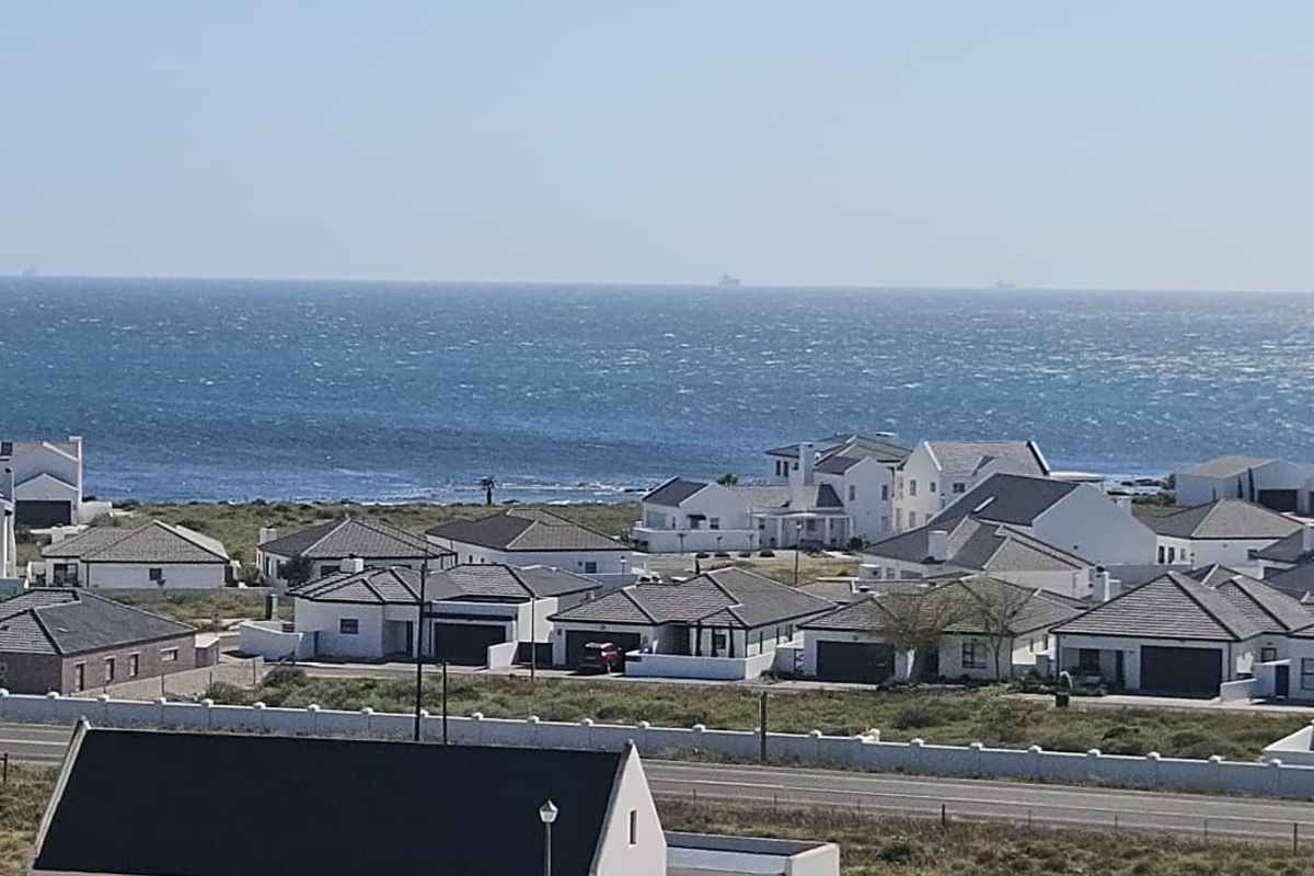 An elevated view overlooking a coastal residential estate with ocean vistas in the background.