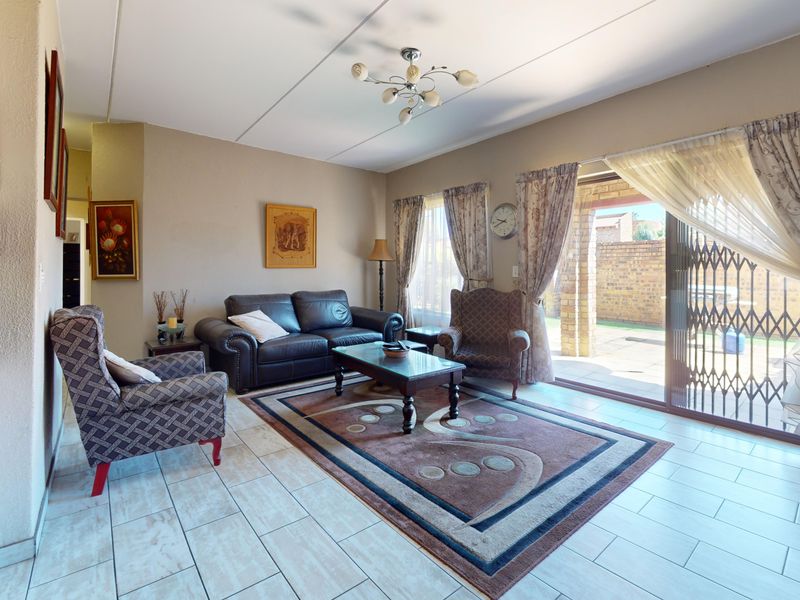 Open plan living area featuring tiled flooring and large sliding glass doors providing direct access to the outdoor patio area.