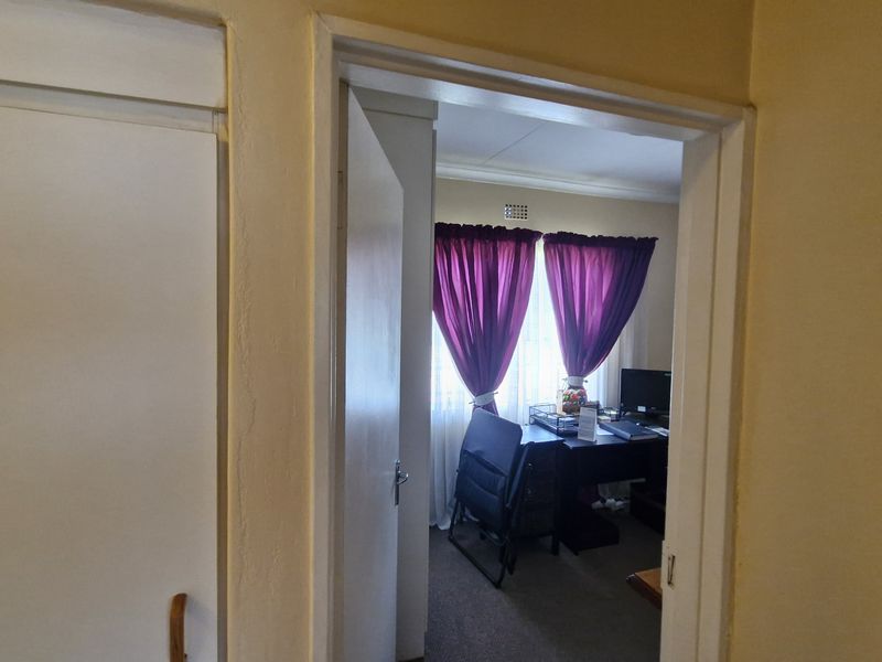 A view through a doorway into a bedroom featuring a built-in cupboard and window.