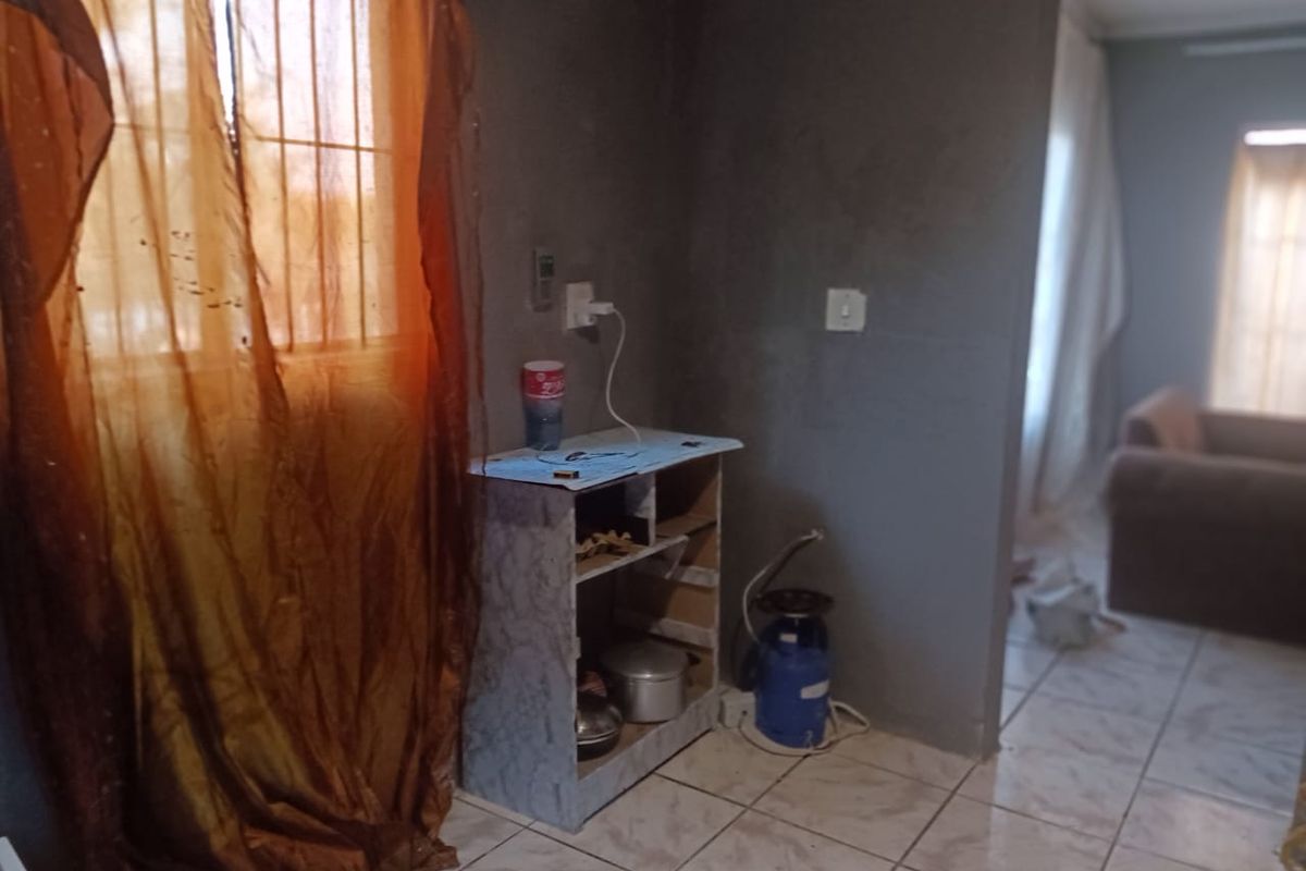 A small kitchen area featuring tiled flooring and basic electrical infrastructure, currently requiring significant renovation and finishing to improve functionality and aesthetic appeal.
