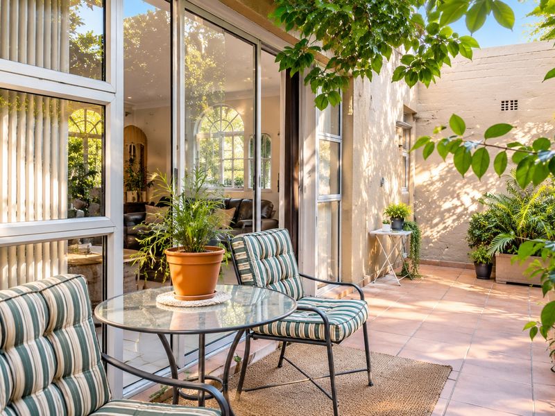 A covered patio area featuring tiled flooring and large sliding glass doors that provide seamless access to the interior living space.