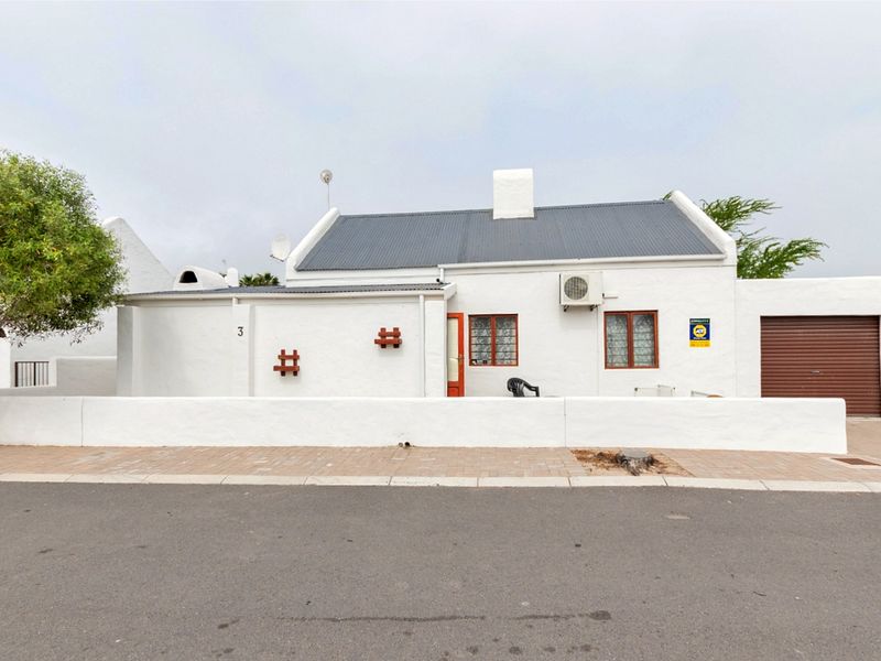 Front elevation of a white cottage-style house featuring a corrugated metal roof, chimney, integrated garage, and a low boundary wall facing the street.