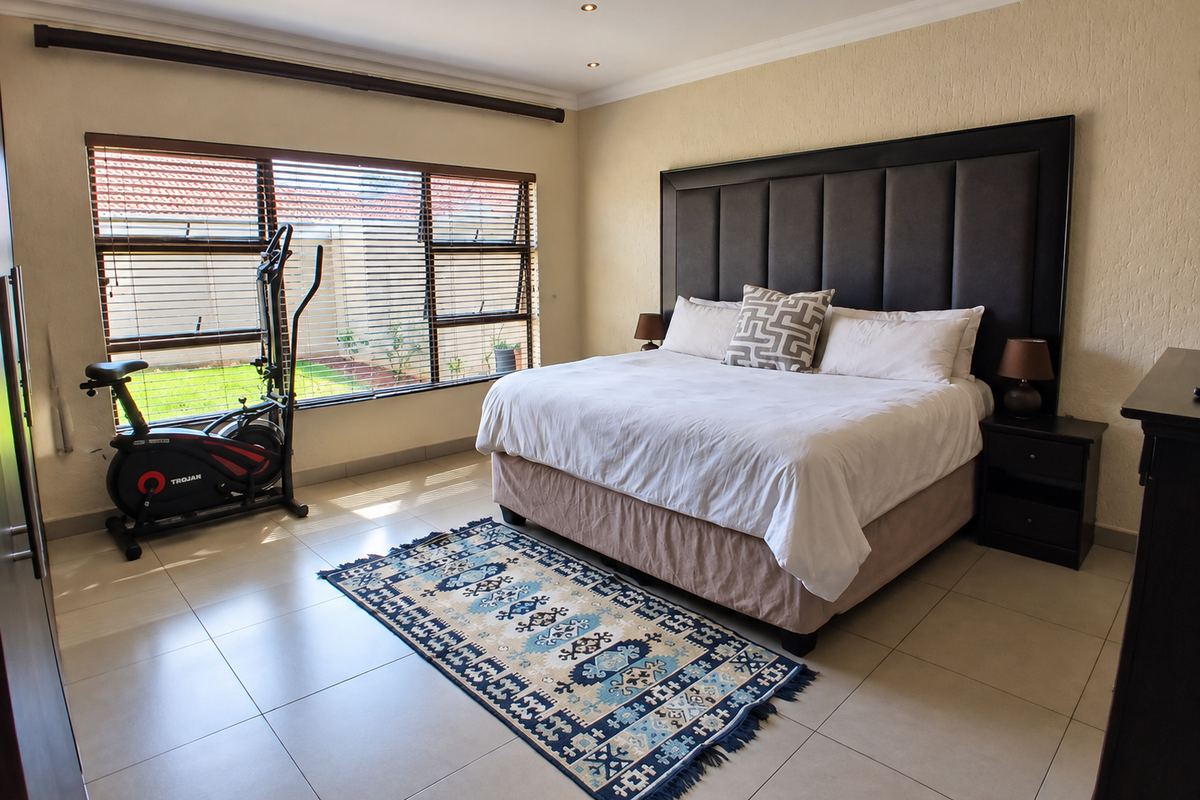 Spacious bedroom featuring tiled flooring, recessed downlighting, and large windows with fitted blinds, offering a bright and comfortable living space.