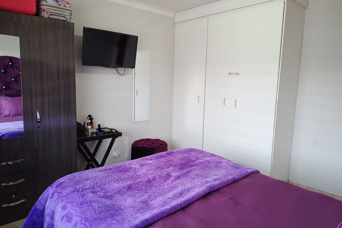 A bedroom featuring a built-in wardrobe with white doors and neutral wall finishes.
